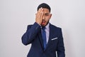 Young hispanic man wearing business suit and tie yawning tired covering half face, eye and mouth with hand Royalty Free Stock Photo