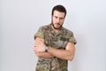 Young hispanic man wearing camouflage army uniform happy face smiling with crossed arms looking at the camera Royalty Free Stock Photo