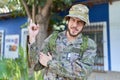 Young hispanic man wearing camouflage army uniform outdoors smiling happy pointing with hand and finger to the side Royalty Free Stock Photo