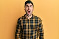 Young hispanic man wearing casual clothes angry and mad screaming frustrated and furious, shouting with anger Royalty Free Stock Photo