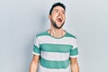 Young hispanic man wearing casual clothes angry and mad screaming frustrated and furious, shouting with anger Royalty Free Stock Photo