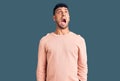 Young hispanic man wearing casual clothes angry and mad screaming frustrated and furious, shouting with anger Royalty Free Stock Photo