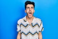 Young hispanic man wearing casual clothes angry and mad screaming frustrated and furious, shouting with anger Royalty Free Stock Photo