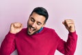 Young hispanic man wearing casual clothes dancing happy and cheerful, smiling moving casual and confident listening to music Royalty Free Stock Photo