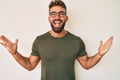 Young hispanic man wearing casual clothes and glasses celebrating victory with happy smile and winner expression with raised hands Royalty Free Stock Photo