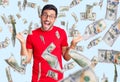 Young hispanic man wearing casual clothes and glasses celebrating victory with happy smile and winner expression with raised hands Royalty Free Stock Photo