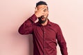 Young hispanic man wearing casual clothes peeking in shock covering face and eyes with hand, looking through fingers afraid Royalty Free Stock Photo