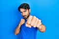 Young hispanic man wearing casual clothes punching fist to fight, aggressive and angry attack, threat and violence