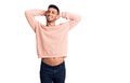 Young hispanic man wearing casual clothes relaxing and stretching, arms and hands behind head and neck smiling happy Royalty Free Stock Photo