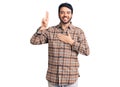 Young hispanic man wearing casual clothes smiling swearing with hand on chest and fingers up, making a loyalty promise oath Royalty Free Stock Photo