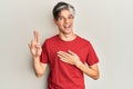 Young hispanic man wearing casual clothes smiling swearing with hand on chest and fingers up, making a loyalty promise oath Royalty Free Stock Photo