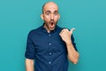 Young hispanic man wearing casual clothes surprised pointing with hand finger to the side, open mouth amazed expression Royalty Free Stock Photo