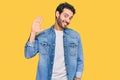 Young hispanic man wearing casual clothes waiving saying hello happy and smiling, friendly welcome gesture