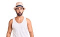 Young hispanic man wearing casual summer hat making fish face with lips, crazy and comical gesture Royalty Free Stock Photo