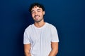 Young hispanic man wearing casual white t shirt looking positive and happy standing and smiling with a confident smile showing Royalty Free Stock Photo