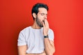 Young hispanic man wearing casual white tshirt bored yawning tired covering mouth with hand Royalty Free Stock Photo