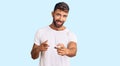 Young hispanic man wearing casual white tshirt pointing fingers to camera with happy and funny face Royalty Free Stock Photo