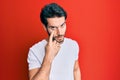 Young hispanic man wearing casual white tshirt pointing to the eye watching you gesture, suspicious expression Royalty Free Stock Photo