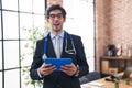 Young hispanic man wearing doctor stethoscope at the office winking looking at the camera with sexy expression, cheerful and happy Royalty Free Stock Photo