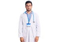 Young hispanic man wearing doctor uniform and stethoscope looking sleepy and tired, exhausted for fatigue and hangover, lazy eyes Royalty Free Stock Photo