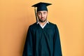 Young hispanic man wearing graduation cap and ceremony robe depressed and worry for distress, crying angry and afraid Royalty Free Stock Photo