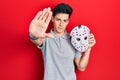 Young hispanic man wearing hockey mask with open hand doing stop sign with serious and confident expression, defense gesture