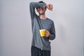 Young hispanic man wearing pajama drinking a cup of coffee smiling cheerful playing peek a boo with hands showing face Royalty Free Stock Photo