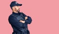 Young hispanic man wearing police uniform looking to the side with arms crossed convinced and confident Royalty Free Stock Photo