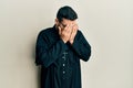 Young hispanic man wearing priest uniform standing over white background with sad expression covering face with hands while crying Royalty Free Stock Photo