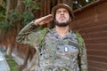 Young hispanic man wearing soldier uniform doing army salute at park Royalty Free Stock Photo