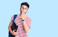 Young hispanic man wearing student backpack and glasses holding binder covering mouth with hand, shocked and afraid for mistake Royalty Free Stock Photo