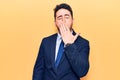 Young hispanic man wearing suit bored yawning tired covering mouth with hand Royalty Free Stock Photo