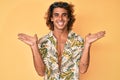 Young hispanic man wearing summer shirt celebrating victory with happy smile and winner expression with raised hands Royalty Free Stock Photo