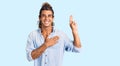 Young hispanic man wearing summer style smiling swearing with hand on chest and fingers up, making a loyalty promise oath