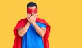 Young hispanic man wearing super hero costume shocked covering mouth with hands for mistake Royalty Free Stock Photo