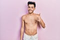 Young hispanic man wearing swimwear shirtless doing happy thumbs up gesture with hand