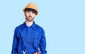 Young hispanic man wearing worker uniform relaxed with serious expression on face Royalty Free Stock Photo