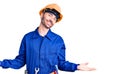 Young hispanic man wearing worker uniform smiling showing both hands open palms, presenting and advertising comparison and balance Royalty Free Stock Photo