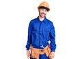 Young hispanic man wearing worker uniform winking looking at the camera with sexy expression, cheerful and happy face Royalty Free Stock Photo