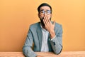 Young hispanic man working at the office bored yawning tired covering mouth with hand Royalty Free Stock Photo