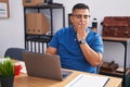 Young hispanic man working at the office with laptop bored yawning tired covering mouth with hand Royalty Free Stock Photo