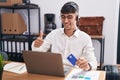 Young hispanic man working using computer laptop holding credit card approving doing positive gesture with hand, thumbs up smiling Royalty Free Stock Photo