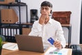 Young hispanic man working using computer laptop holding credit card bored yawning tired covering mouth with hand Royalty Free Stock Photo