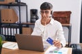 Young hispanic man working using computer laptop holding credit card laughing and embarrassed giggle covering mouth with hands, Royalty Free Stock Photo