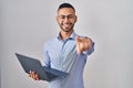 Young hispanic man working using computer laptop pointing to you and the camera with fingers, smiling positive and cheerful Royalty Free Stock Photo