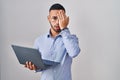 Young hispanic man working using computer laptop yawning tired covering half face, eye and mouth with hand Royalty Free Stock Photo