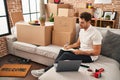 Young hispanic man writing on book sitting on sofa at new home Royalty Free Stock Photo