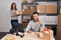 Young hispanic people working at small business ecommerce smiling happy pointing with hand and finger Royalty Free Stock Photo