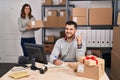 Young hispanic people working at small business ecommerce smiling happy pointing with hand and finger to the side Royalty Free Stock Photo