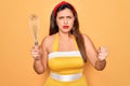 Young hispanic pin up woman wearing fashion sexy 50s style holding cooking whisk blender annoyed and frustrated shouting with Royalty Free Stock Photo